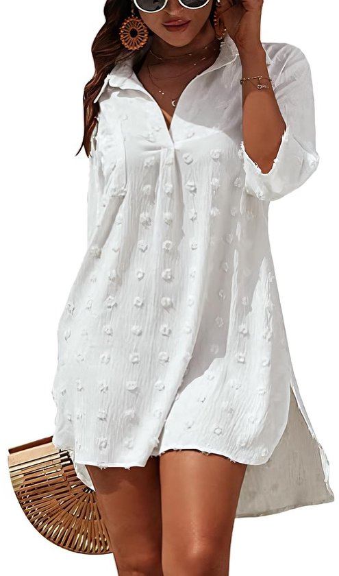 Vrouw in witte V-hals strandjurk met popprint, 3/4 mouwen en zijsplitten, met mandtas.