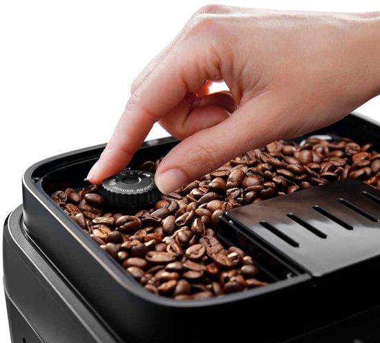 Hand draait aan knop 'Grinder Adjust' in reservoir gevuld met koffiebonen.