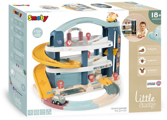 Doos van een Little Smoby garage met gele glijbaan, auto's en een helikopter. "Grand garage Big garage".