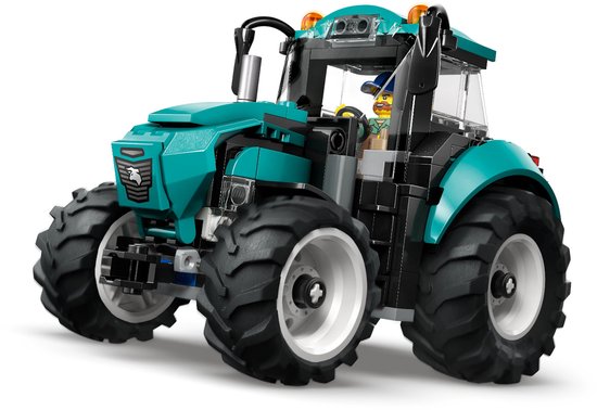 Felgroene tractor met grote banden, witte velgen, vanuit een lage hoek.