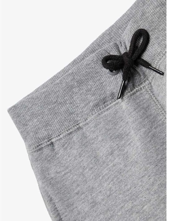 Detail van de tailleband en het trekkoord van een grijze joggingbroek.