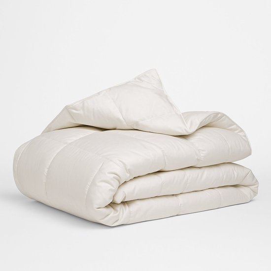 Couette blanche en duvet pliée avec des coutures carrées.