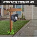 Zwarte IP52 waterdichte hoes met witte bewegingssensor op een houten paal bij regen.
