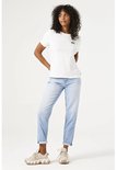 Model draagt een witte T-shirt met zwarte panterprint en een lichtblauwe mom fit jeans.