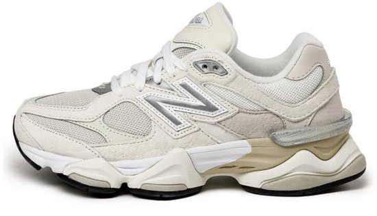 Witte New Balance sneaker met beige en zilveren details, zijaanzicht.