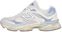 Zijkant van een beige en lichtblauwe New Balance 9060 sneaker, staand op de grond.