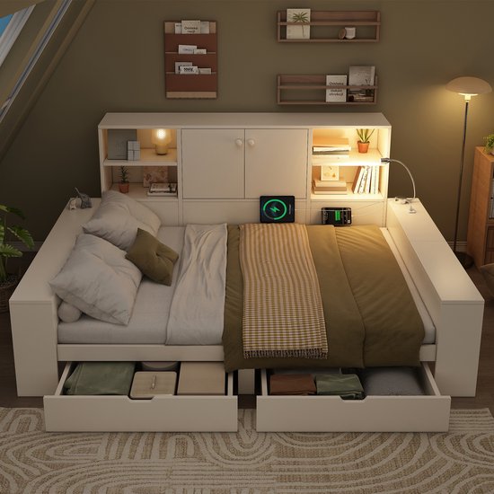 Wit opbergbed met bruine ruitjesdeken, lades en open kasten met verlichting, in een zolderkamer.