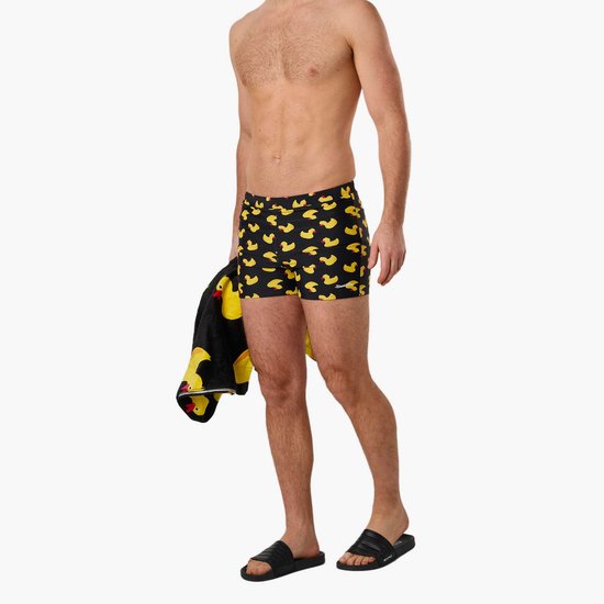 Man met zwembroek met badeendjesprint en zwarte handdoek met badeendjes