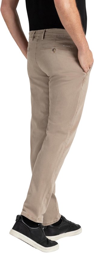 Achterkant van man in beige chino broek met MAC JEANS logo en zwarte sneakers.