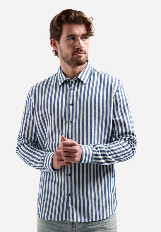 Model in blauw en wit gestreept overhemd, handen in elkaar.