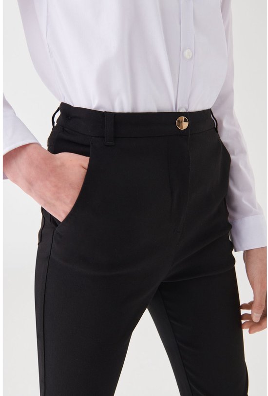 Close-up van de zwarte broek met gouden knoop en steekzak op de heup.