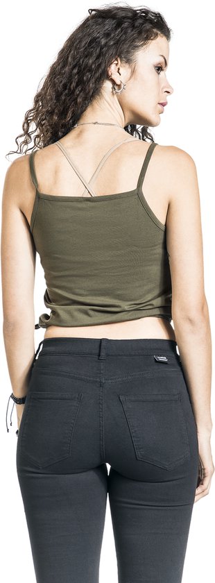 Achterkant van een vrouw in olijfgroene top met dunne bandjes en zwarte jeans.