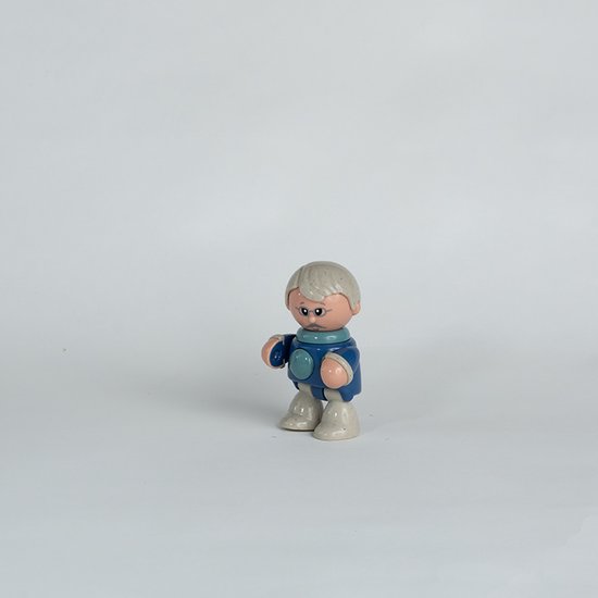 Speelfiguur van opa met grijze haren, blauw pak met ronde details en lichte schoenen.