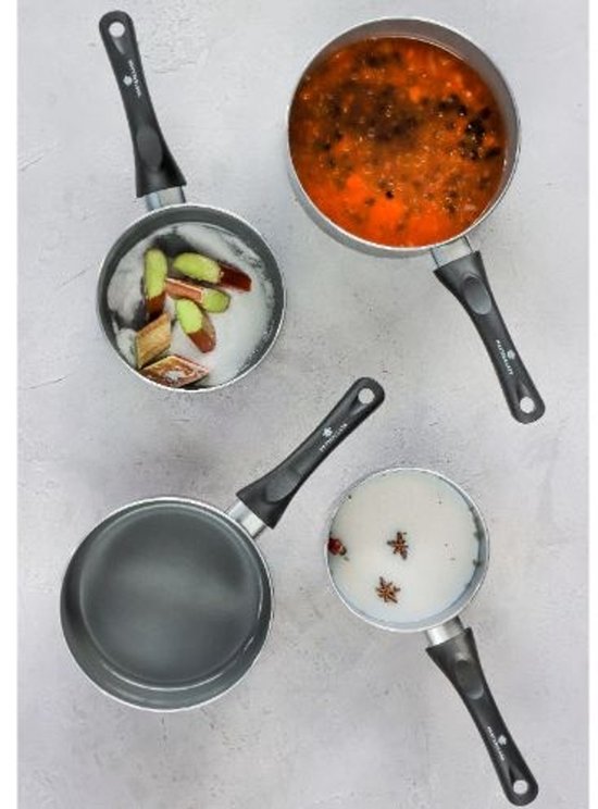 Trois casseroles Masterclass sur un plan de travail : une avec sauce rouge, une avec rhubarbe et sucre, et une vide.