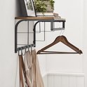 Close-up van een wandkapstok met een houten plank, metalen frame, kledingroede, 5 haken en een tas eraan.