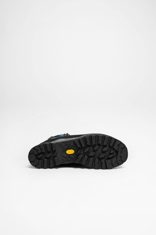 Zwarte Vibram zool met diep profiel van een blauwe Lowa wandelschoen.