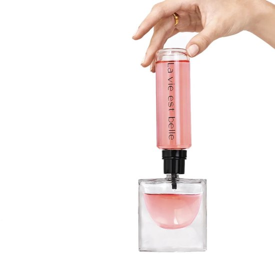 Hand vult Lancôme La Vie est Belle parfum bij uit navulfles. Roze parfum.