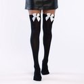 Zwarte kniekousen met witte strikjes, gedragen met een zwarte leren rok en schoenen.
