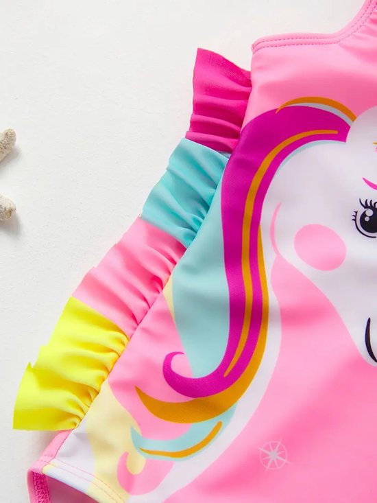 Roze badpak met ruches en een grote print van een eenhoorn met roze, gele en blauwe manen.