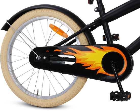 Achterwiel van zwarte kinderfiets met beige band, vlammenprint op de kettingkast en reflectoren.