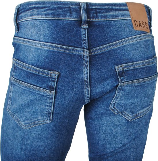 Achterkant van een herenjeans met bruin 'CARS' label en denim in een donkerblauwe, gebruikte wassing.