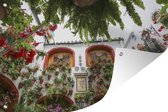 Tuinposter - Tuindoek - Tuinposters buiten - Rode bloemen aan de muur in het Spaanse Córdoba - 120x80 cm - Tuin