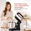 Vrouw voegt bloem toe aan de kantelbare metalen mengkom van een zwarte Broba mixer.