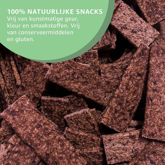 Een hoop bruine, gedroogde, rechthoekige hondensnoepjes. "100% natuurlijke snacks. Vrij van kunstmatige geur, kleur en smaakstoffen. Vrij van conserveermiddelen en gluten."