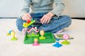 Kind speelt met Hans en Grietje logisch spel met gekleurde ballen, figuren, een huisje en een opdrachtenboekje.