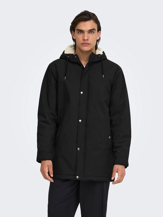 Zwarte parka met capuchon en crèmekleurige voering, gedragen door een model tegen een witte achtergrond.