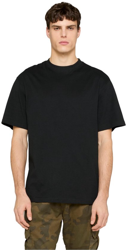 Voorkant van een zwart Urban Classics T-shirt gedragen door een man met camouflagebroek.