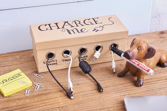 Sausage dog beeldje met edding 3000 marker, naast een doos voor het opladen van telefoons.