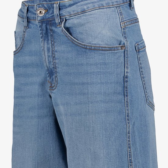 Close-up van een blauwe spijkerbroek taille met knoopsluiting waarop 'TwoDay Denim' staat.