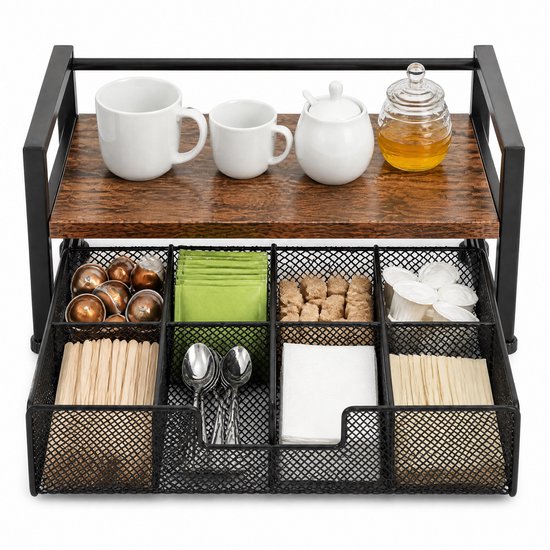 Een bruine en zwarte metalen organizer met 2 verdiepingen, gevuld met theezakjes, koffiecups, suiker, lepels, mokken, honing en potten.