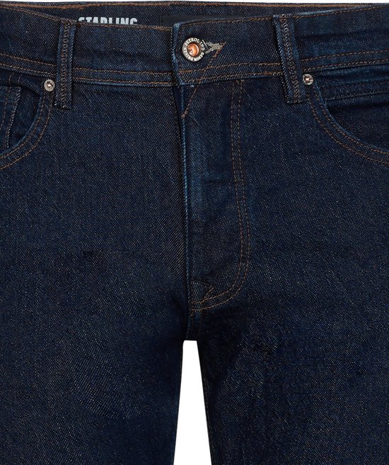 Donkerblauwe Petrol Industries Starling jeans met koperkleurige knoop, rits en bruine stiksels.