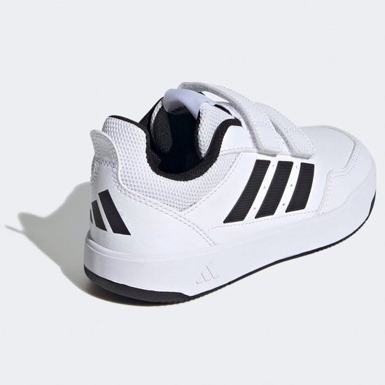 Witte kindersneakers met klittenbandsluiting, zwarte strepen op de zijkant, achterkant en zool.