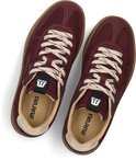 Paar bordeauxrode lage sneakers met beige veters en Maruți-logo op de binnenzool.