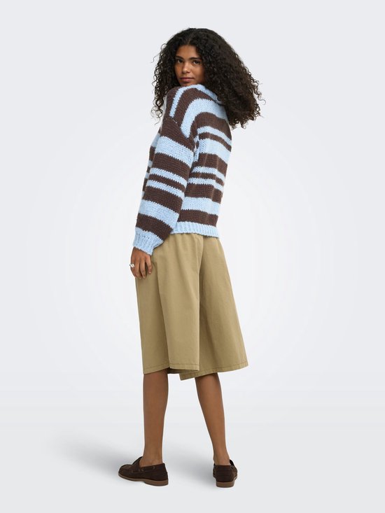 Model draagt lichtblauwe en bruine gestreepte trui met ronde hals en beige culotte.