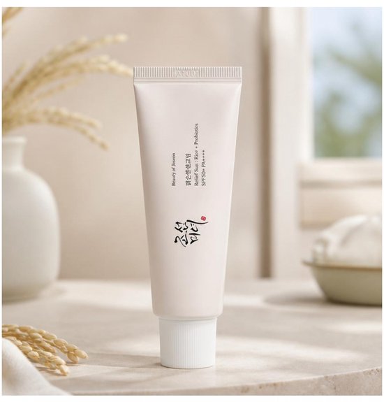 Tube blanche avec inscription 'Beauty of Joseon Relief Sun: Rice + Probiotics SPF 50+ PA++++', entourée d'épis de riz.