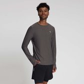 Man met lange grijze sportshirt met duimgaten, staand met één hand in zijn zak.