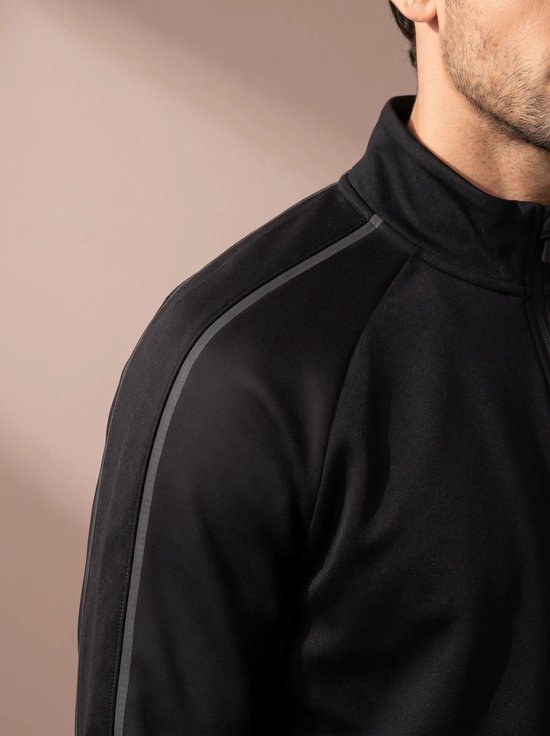 Close-up van zwart sportvest met grijze accentstreep op de schouder en kraag.