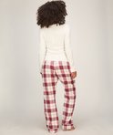 Achteraanzicht van model in een crème top en een rood-witte ruitbroek.
