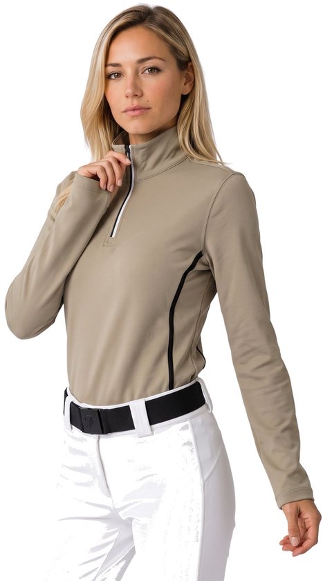 Model draagt een champagnekleurige Falcon skipully met halve rits en zwarte accenten op een witte broek.