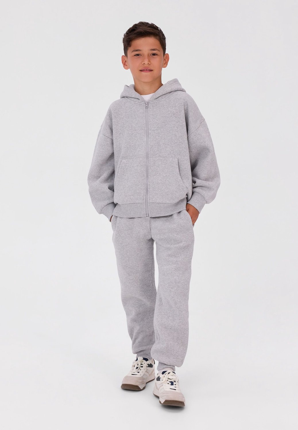 Minoti trainingspak jongens – ritsvest met capuchon – smalle broek – lichtgrijs