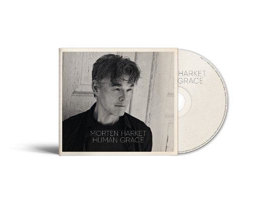 Zwart-wit hoes van Morten Harket - Human Grace CD met portretfoto van de artiest tegen een houten achtergrond.