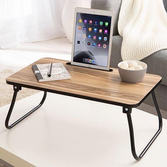Houten bedtafel met tablet, notitieboekje en schaal met kommetjes.