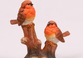 Beeldje vogels op boomstronk levensecht