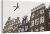 Schilderij - Vliegtuig boven Amsterdam — 90x60 cm