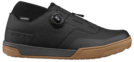 Een zwarte Shimano fietsschoen met bruine zool, BOA-sluiting en perforaties. De schoen heeft de letters GFZ op de zijkant.