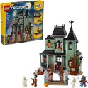 Une maison hantée verte avec des figurines de zombies, vampires, fantômes et un loup-garou.